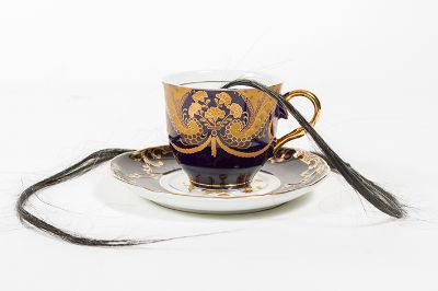 "Tea Time" es una obra conformada por una taza europea desde la que se desprenden hebras de pelo negro, aludiendo a la historia de Fueguia Basket.