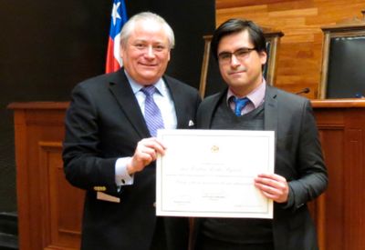 El Presidente del Tribunal Constitucional, Ministro Iván Aróstica Maldonado, entregando el reconocimiento del primer lugar a Esteban Rocha Fajardo.