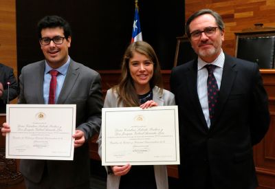 Joaquín Gabriel Araneda Lira y Catalina Salcedo Pacheco, recibiendo su reconocimiento junto al profesor del Departamento de Derecho Público, José Ignacio Vásquez.