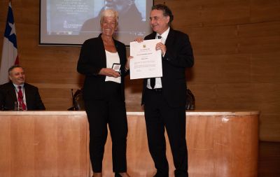 La profesora Mónica Pinto recibiendo el diploma que le confiere el grado de Doctor Honoris Causa de la Universidad de Chile.