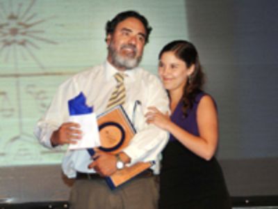 El doctor Hugo Sanhueza, de Campus Norte, recibe el premio como mejor docente de manos de la doctora Lara Fernández.