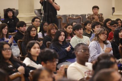 Estudiantes sentados, mirando hacia el frente en el Salón de Honor de la U. de Chile