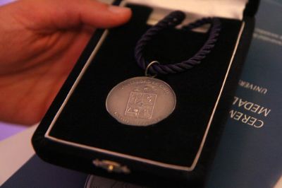 La "Medalla Doctoral Universidad de Chile" consiste en un disco de plata de 38 milímetros, con argolla y contra argolla para colgar.
