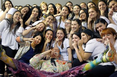 El doctor Patch Adams se fotografió con las estudiantes de Enfermería de la Universidad de Chile tras el encuentro "Humanización de la Formación para un Cuidado Digno". 