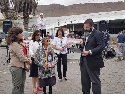 El coordinador académico de la Cátedra de Derechos Humanos, Claudio Nash, haciendo entrega del título póstumo y simbólico de Héctor Orellana Rojas a su madre, Fresia Rojas.