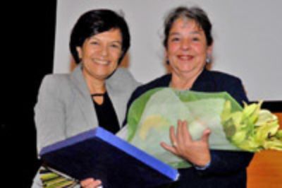 Ester González, premiada por su trayectoria laboral, recibe su premio de parte de la doctora Graciela Rojas