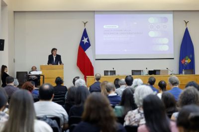 Vicerrector Claudio Pastenes hablando en la testera de una sala Eloísa Díaz llena de docentes de la U. de Chile