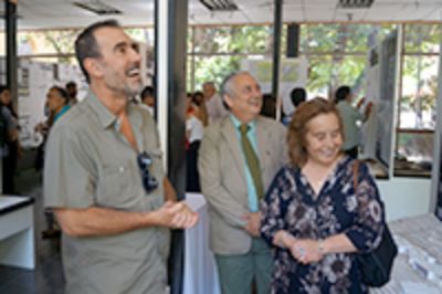 Cristian Campos junto a vicedecano Rubén Sepúlveda y Decana Marcela Pizzi observando uno de los trabajos