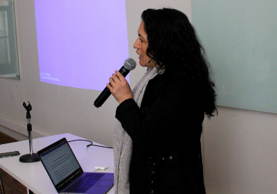 Maribel Mora Curriao dando unos palabras de bienvenida e introducción a la charla de Marco Avilés.