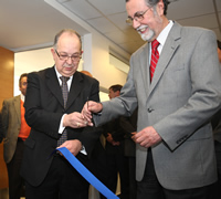 El decano Roberto Nahum corta la cinta de inauguración de las nuevas dependencias acompañado del rector de la U. de Chile, Víctor Pérez. 