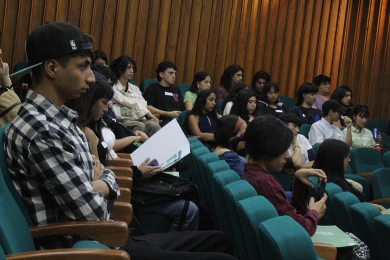 Estudiantes escuchan las exposiciones en la ceremonia de bienvenida 2023